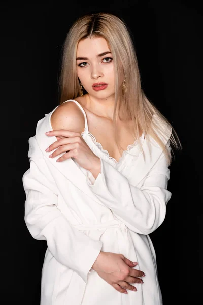 Portrait en gros plan de belle jeune mannequin avec des cheveux blonds et des vêtements noirs, posant en photostudio sur fond sombre — Photo