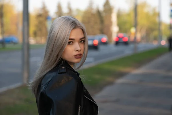 Mladá módní blondýnka v kožené bundě s kabelkou na ulici — Stock fotografie