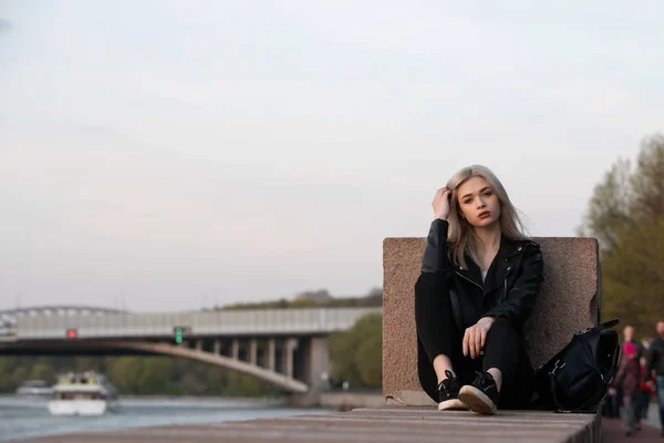 Jonge mode blonde vrouw in lederen jas met handtas op straat — Stockfoto