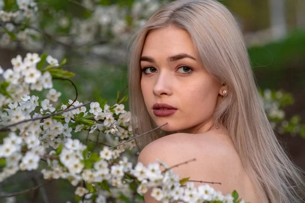 Bahar kiraz bahçesinde güzel sarışın kız