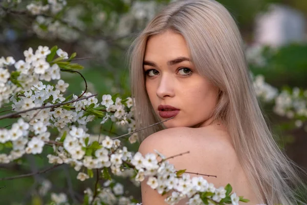 Bahar kiraz bahçesinde güzel sarışın kız
