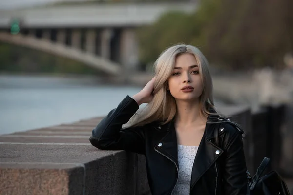 Jonge mode blonde vrouw in lederen jas met handtas op straat — Stockfoto