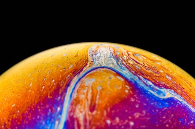 İzole edilmiş siyah bir arka planda gökkuşağı sabun köpüğü. Renkli yüzeye yakın çekim. Poster boş