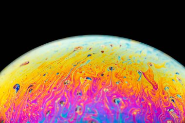 İzole edilmiş siyah bir arka planda gökkuşağı sabun köpüğü. Renkli yüzeye yakın çekim. Poster boş