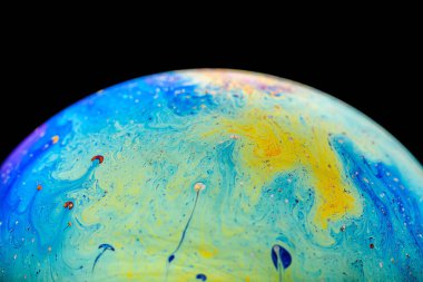 İzole edilmiş siyah bir arka planda gökkuşağı sabun köpüğü. Renkli yüzeye yakın çekim. Poster boş