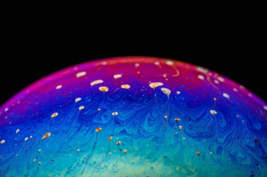 İzole edilmiş siyah bir arka planda gökkuşağı sabun köpüğü. Renkli yüzeye yakın çekim. Poster boş