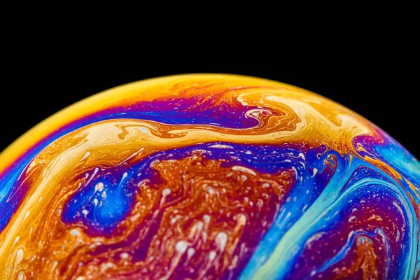 Rainbow soap bubble on an isolated black background. Close-up of the colorful surface. Poster blank — Stock Photo, Image