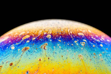 İzole edilmiş siyah bir arka planda gökkuşağı sabun köpüğü. Renkli yüzeye yakın çekim. Poster boş