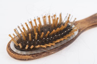 Saç dökülmesine ve saç dökülmesine neden olan sağlık sorunları. Hafif bir yüzeyde kalan saçlarla birlikte kadın ahşap fırçası.