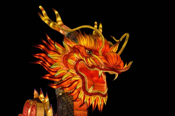 Uma lanterna de dragão chinesa de seda colorida e artesanal está brilhando na noite escura em um festival chinês de luz e lanterna . — Fotografia de Stock