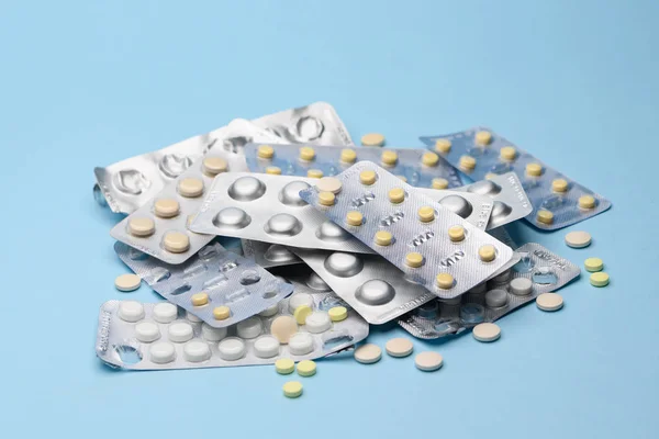 Witte blisterverpakking met tabletten pilstatines voor lichtbestendige verpakkingen op blauwe achtergrond. Witte en gele tabletten — Stockfoto