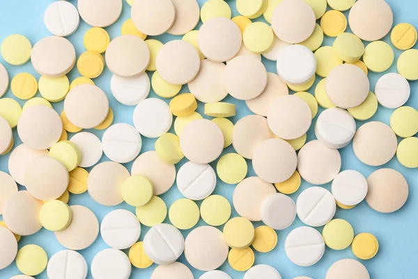 Gele en witte tabletten op een blauwe achtergrond van dichtbij — Stockfoto