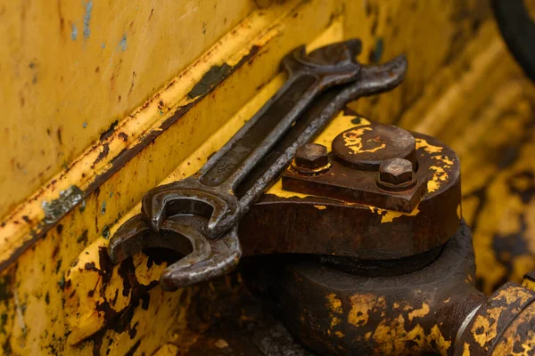 在一台旧的黄色推土机的背景下的扳手 — 图库照片