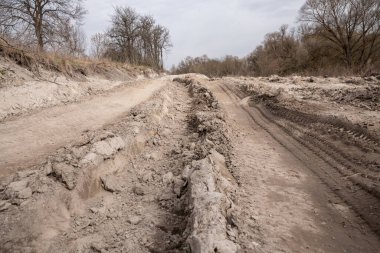 Kötü köy yolu. Ağır bir kamyonun tekerlerinden hasar gören toprak bir yol. Clay, pislik. Kavram: yollarla ilgili sorun; çevre üzerindeki insan etkisi.