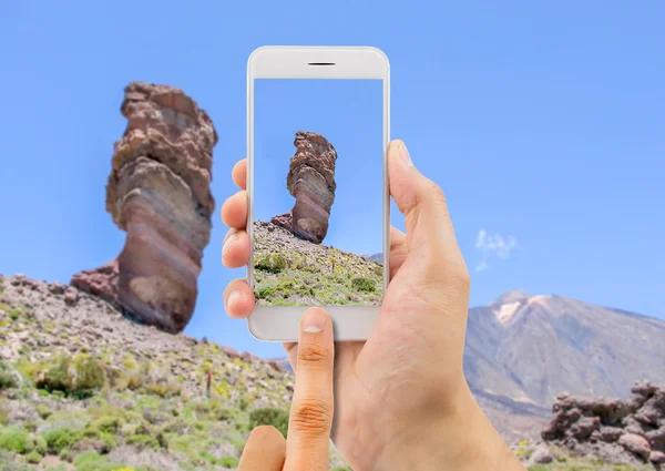 Homem segura o telefone da câmera no Teide — Fotografia de Stock