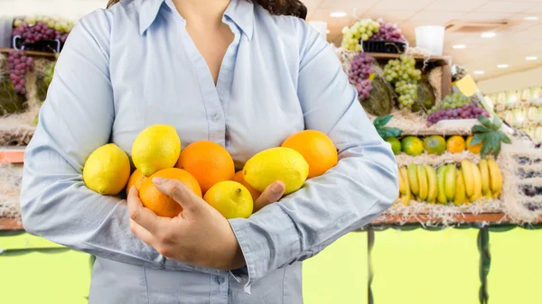 Femme avec des fruits citriques sur le marchand de légumes — Photo