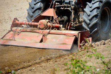 Bir mibzer sürülmüş bir alanın üzerine geç öğlen çekerek bir traktör atış