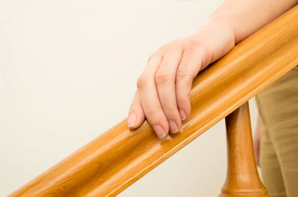 Vrouw hand over een houten reling — Stockfoto
