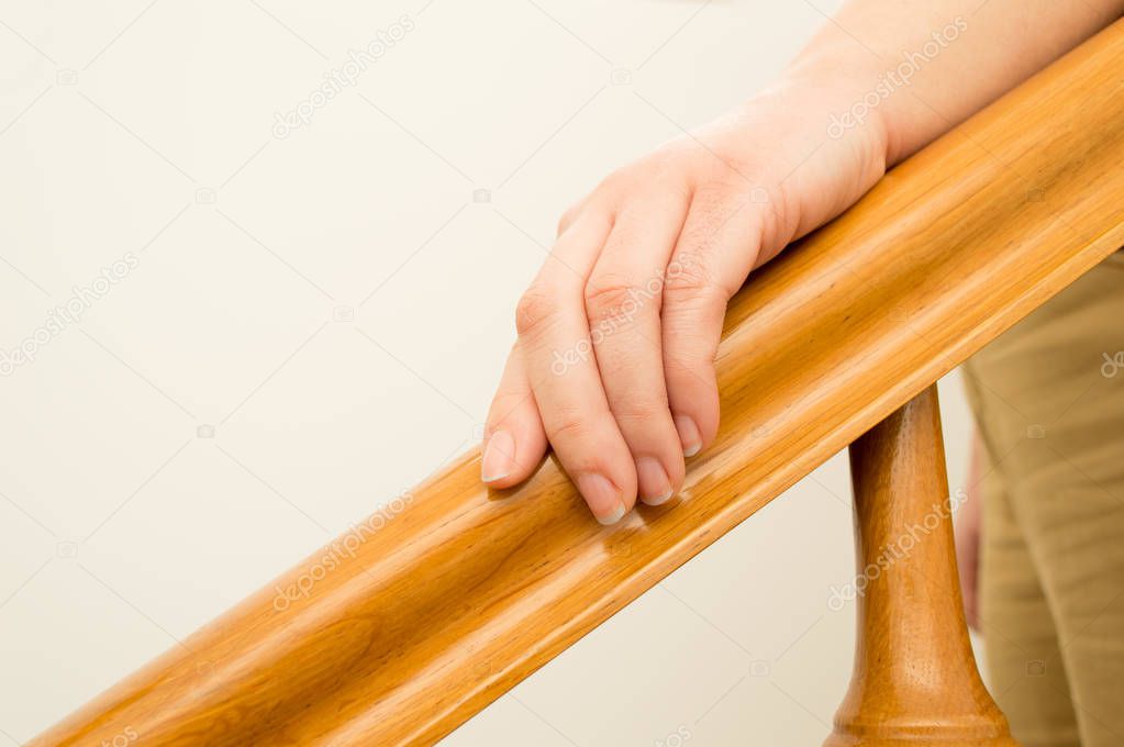 woman hand over a wooden railing 