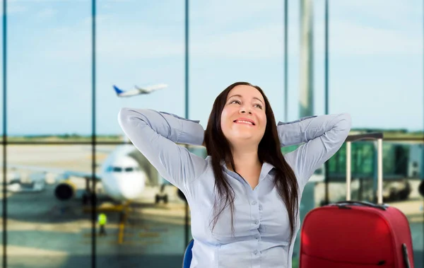 Женщина улыбается в аэропорту — стоковое фото