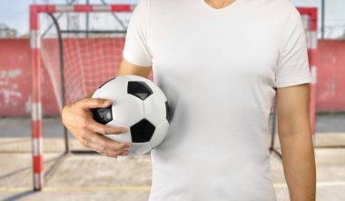 bir futbol topu tutan sportman 