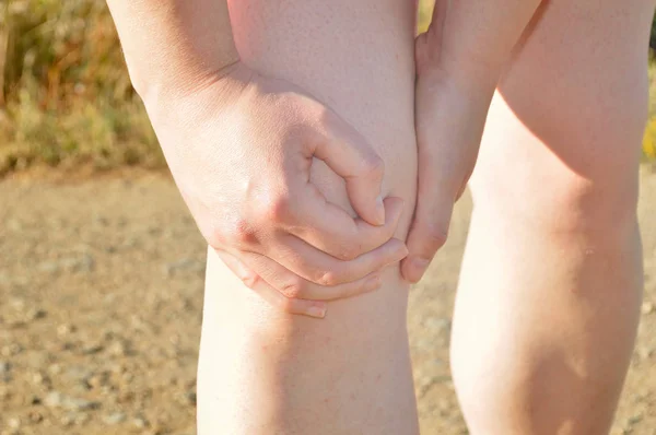 Deportista con un calambre en la rodilla — Foto de Stock