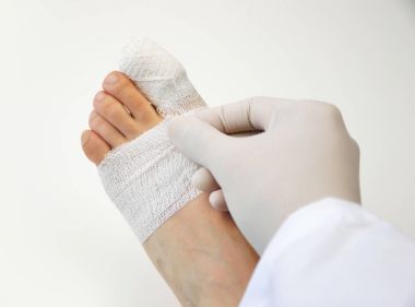 doctor curing the toe of patient clipart