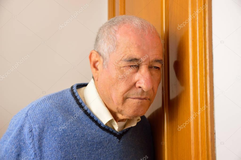 senior man listening behind the door