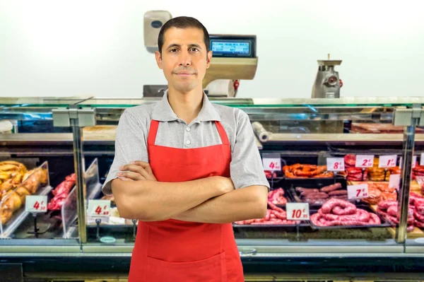 Мясник, скрестивший руки в мясном магазине — стоковое фото