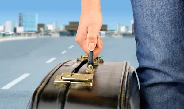 Hitchhiker with suitcase leaving the city — Stock Photo, Image