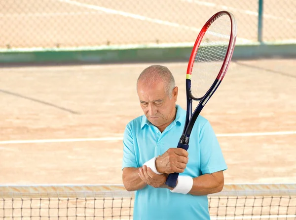 senior tennis player with wrist pain