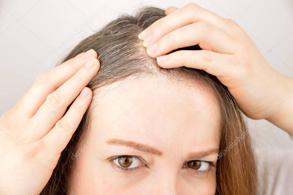 Young woman shows her gray hair