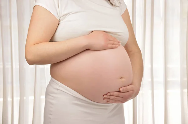 Kvinna med hennes gravid mage — Stockfoto