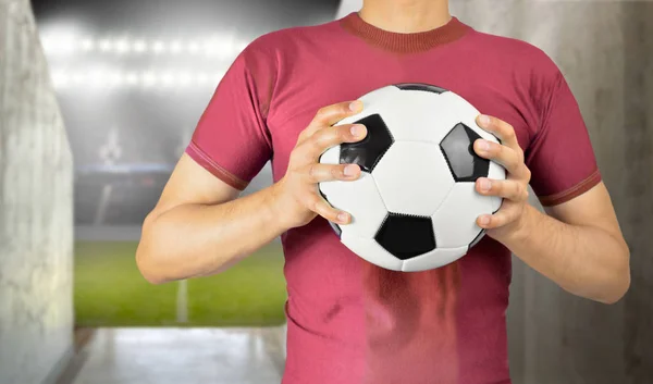 Jugador de fútbol sosteniendo la pelota — Foto de Stock