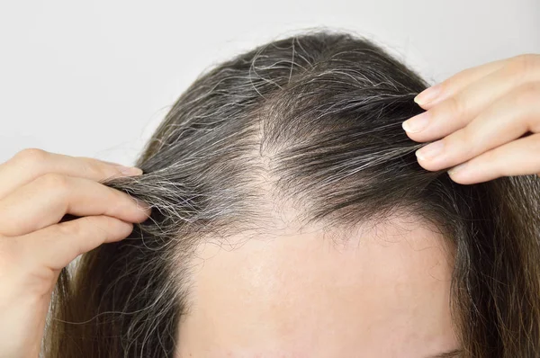 Mujer joven muestra su pelo gris — Foto de Stock