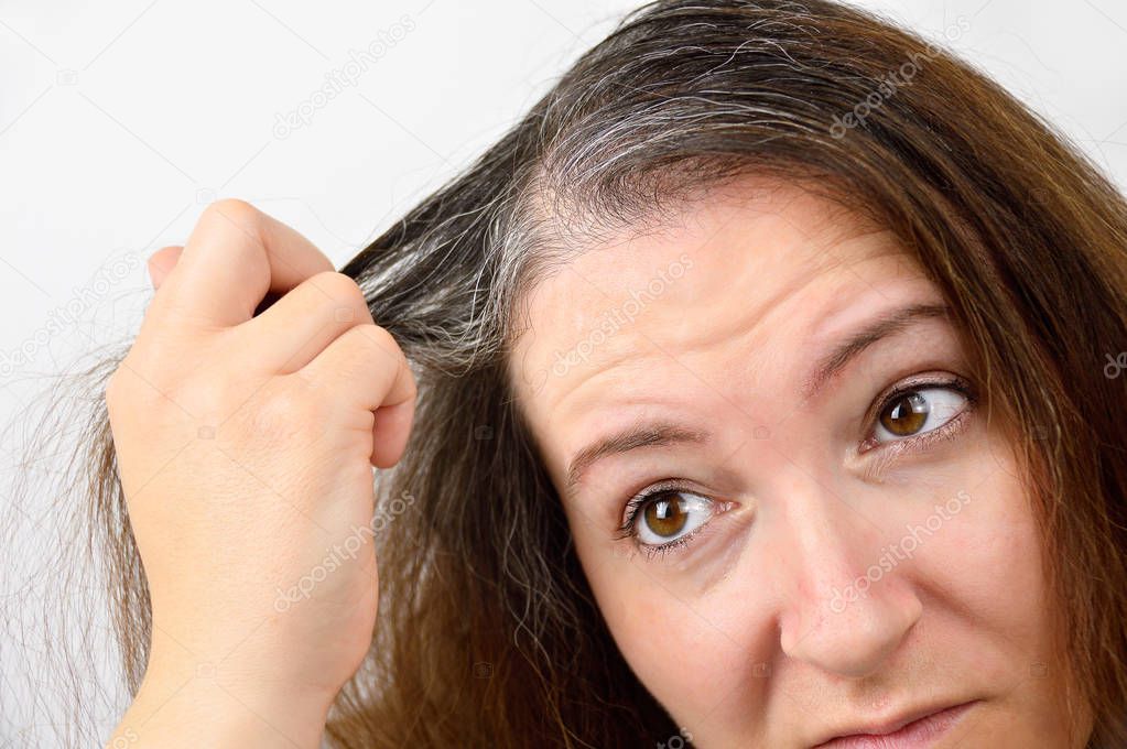 Young woman shows her gray hair