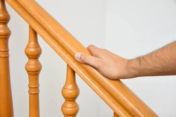 Hand of man over a wooden railing — Stock Photo, Image
