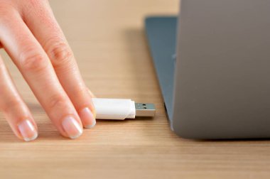 Bir dizüstü bilgisayarda bir masaüstü bir pendrive bağlamak bir kadın el yakın çekim