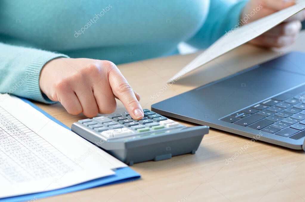 Accountant calculating with a calculator on a desk at office