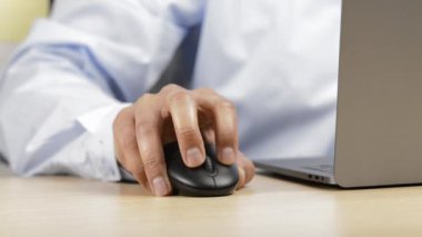 Öfkeli yetişkin bir adam ofisteki bilgisayarın içeriğini kontrol ediyor.