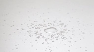 Kırık bir boru yüzünden beyaz zemine düşen ıssız bir su damlasını kapatın.