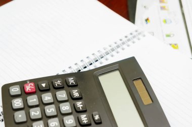 hesap makinesi ve üstünde boş defter kalem.