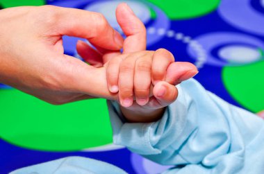 Yeni doğan oğlu sığ Dof elini tutarak anne