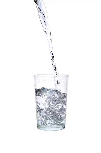 Água doce derramando em um copo sobre fundo branco — Fotografia de Stock