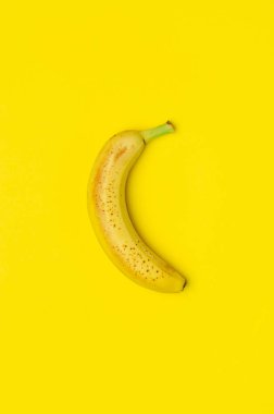 Sarı bir arka plan üzerinde olgunlaşmış muz.