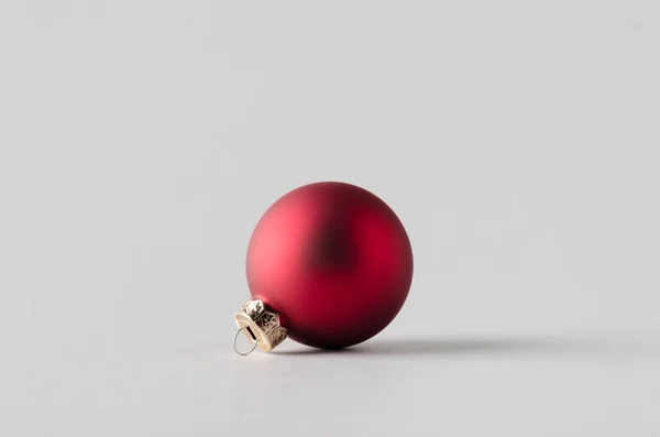 Rode matte kerstbal op een naadloze grijze achtergrond. — Stockfoto