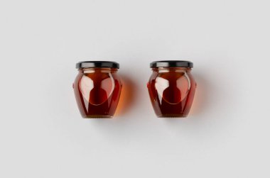 Gri bir arka planda iki bal kavanozu..