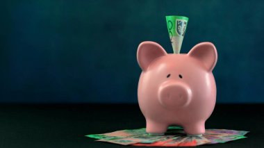 Pink Piggy bank money concept on dark blue background clipart