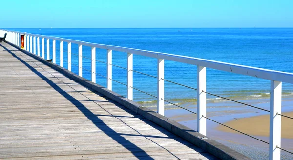 Sunny beach scene from jetty point of view. — Stock Photo, Image