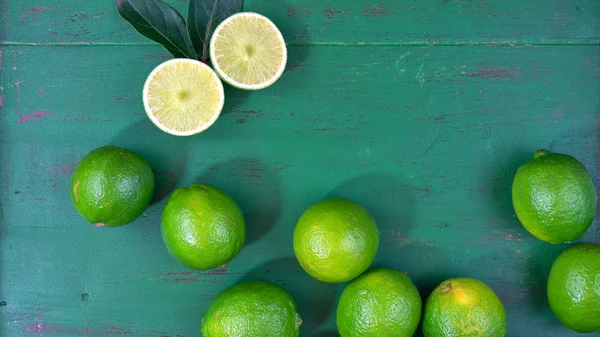 Limes op rustieke donker groene houten tafel — Stockfoto